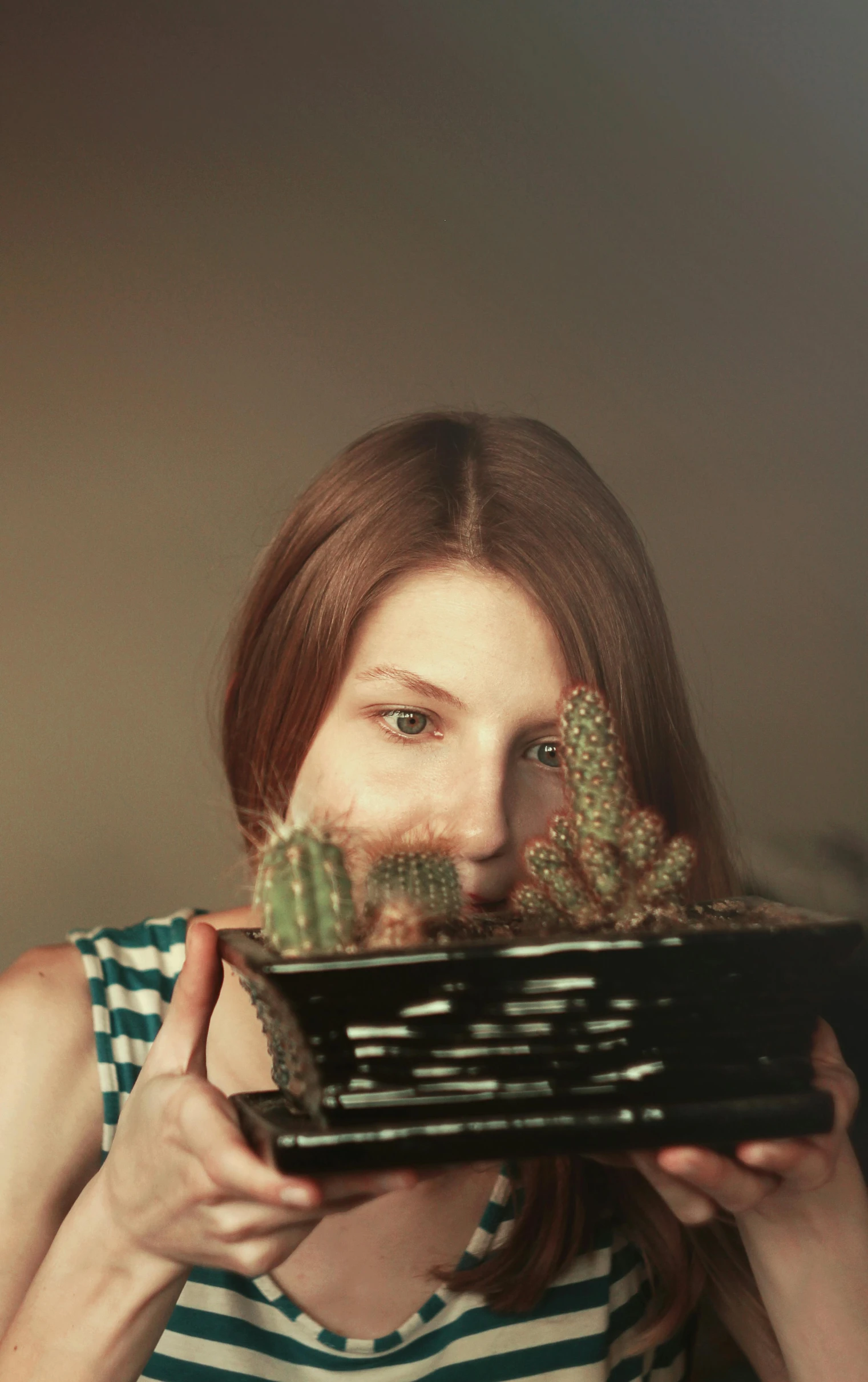 a woman holding up a tray that is full of plants
