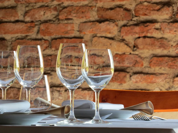 three empty wine glasses and five empty wine glasses sitting on a dining table