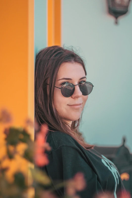 a pretty young lady in dark sunglasses posing