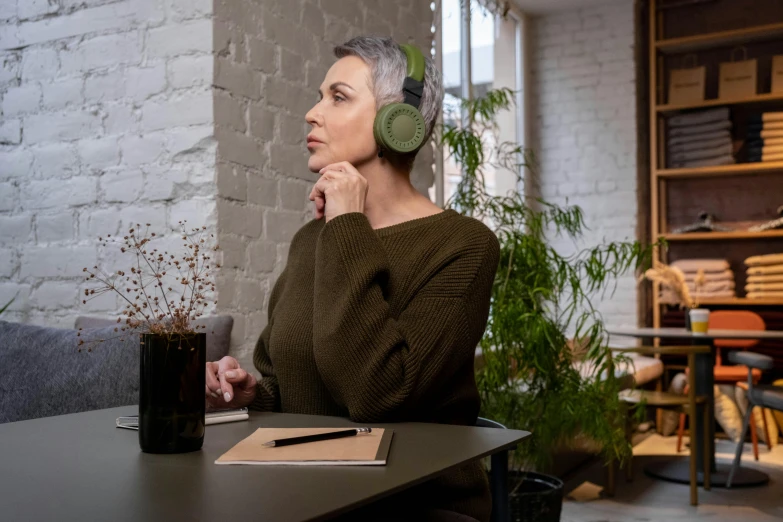 the woman is wearing headphones while sitting at a desk