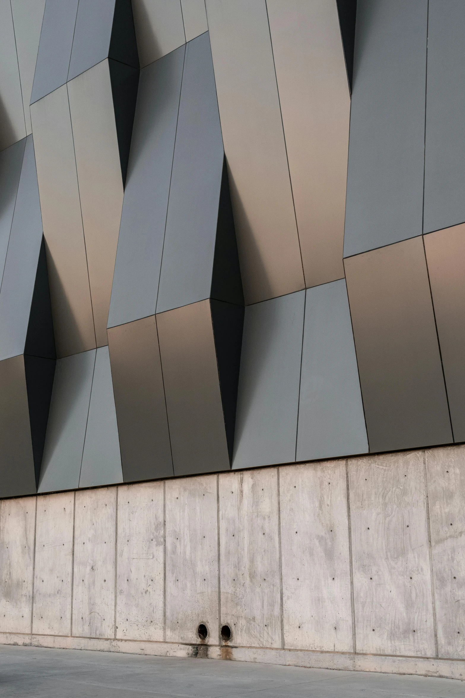 a grey wall that is next to a person sitting on a bench