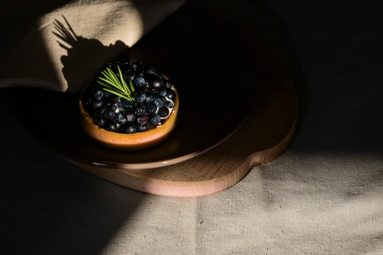 a bowl full of berries on a table next to a cloth