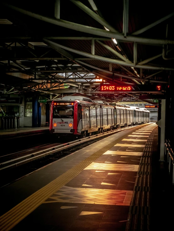 a subway train at the station with lights on and people in it