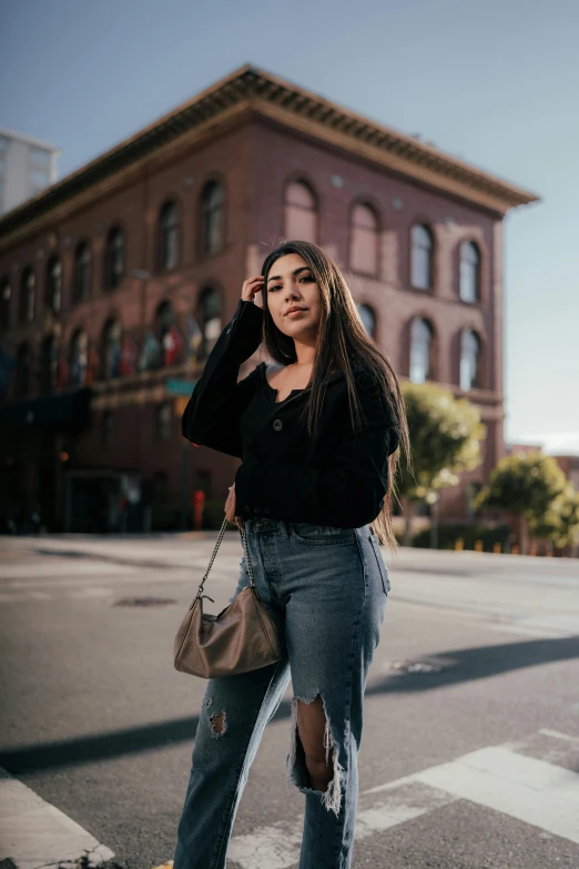 a woman standing in the middle of a street talking on her phone