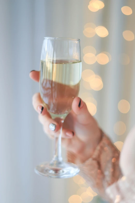 a close up of a person holding a wine glass