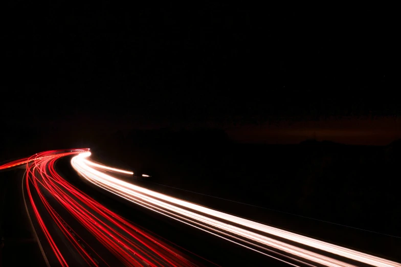 cars speeding by at night on the highway with many headlights