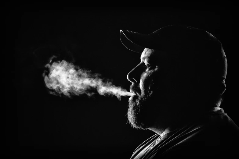 a man in black with smoke coming out of his face