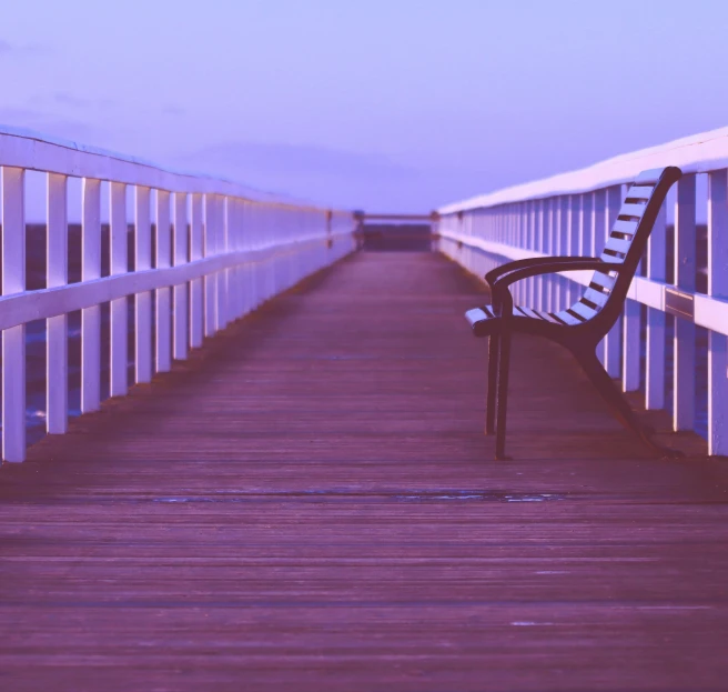 a black bench sitting on top of a wooden deck