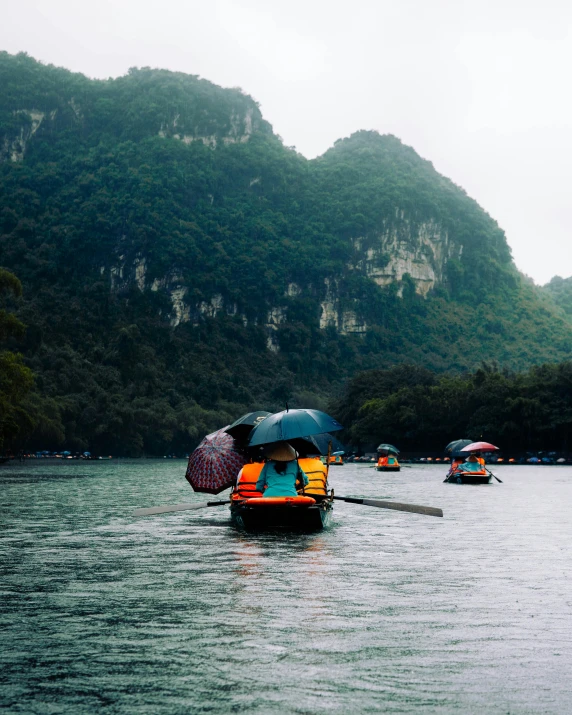 people on small boat in body of water with umbrellas