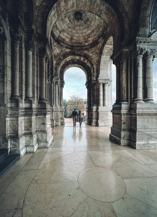 people are walking through an archway between two buildings