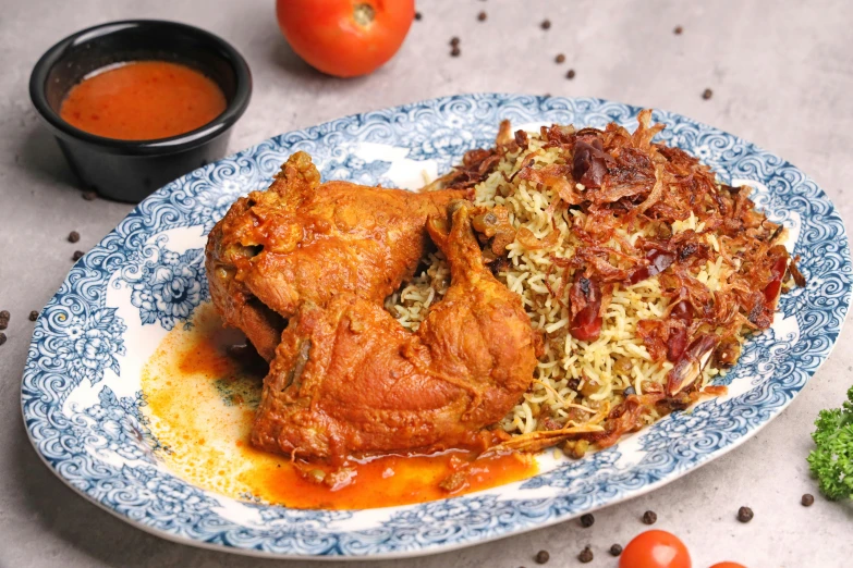 a plate topped with meat covered in rice and tomatoes