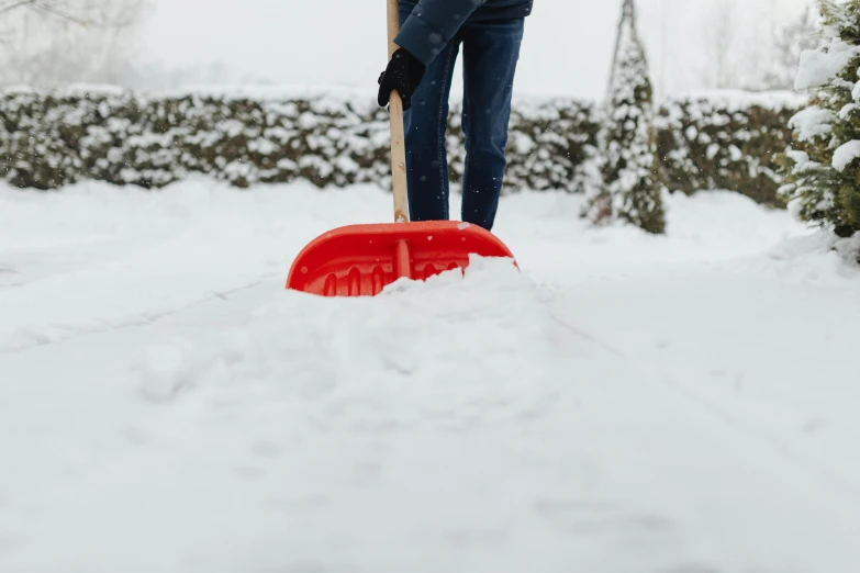 the woman is using her shovel to dig deep snow