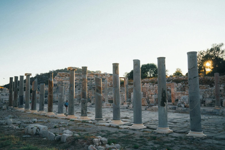 a row of stone pillars with people standing between them