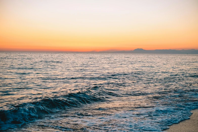 the ocean with a body of water and sand