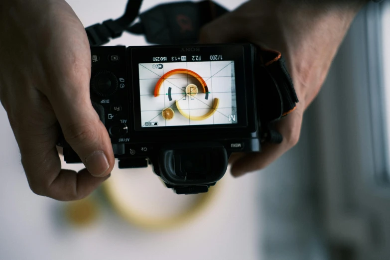 a camera in a persons hand holding a camera