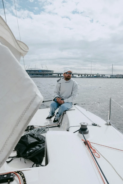 a man sits at the end of a sailboat