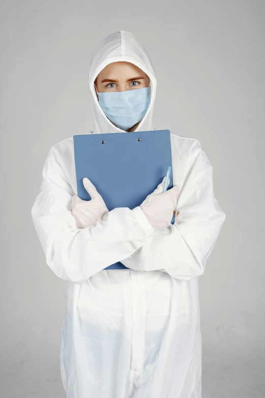 man wearing medical clothing holding a binder in both hands