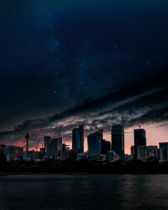 the night sky over a city skyline from a river