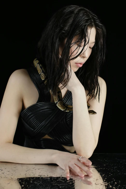 a woman in black lingerie leaning on table