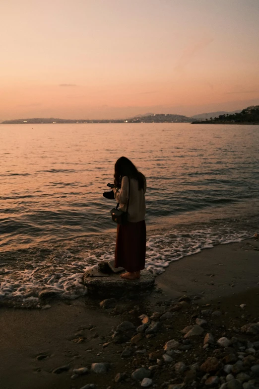 a woman standing on the edge of a body of water