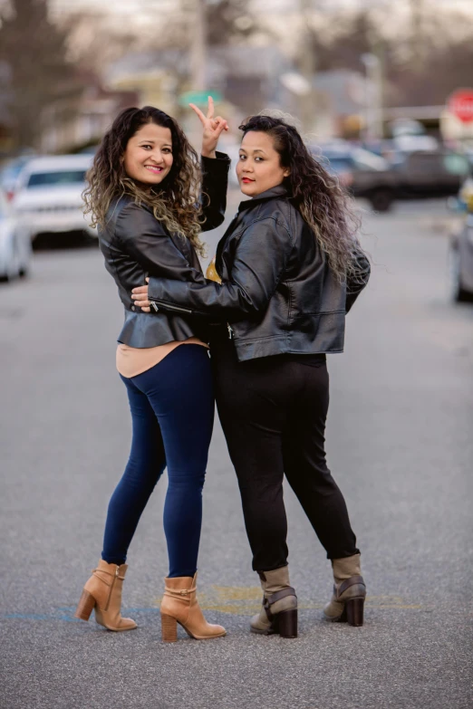 two girls are standing next to each other on the street