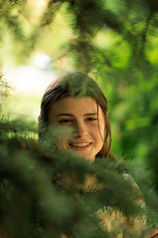 a woman smiling while standing in the forest