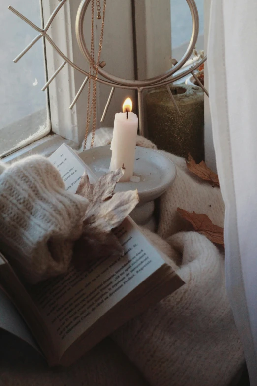 two candles are lit on an open book