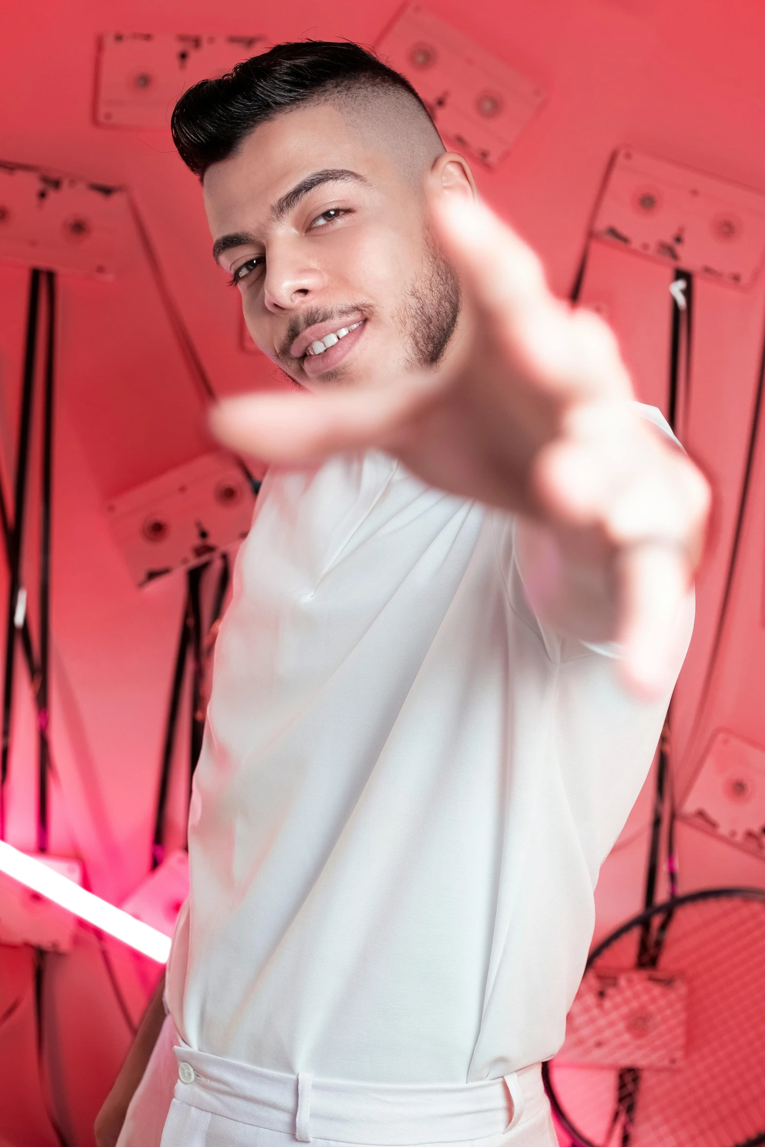 the man is making a peace sign near many records