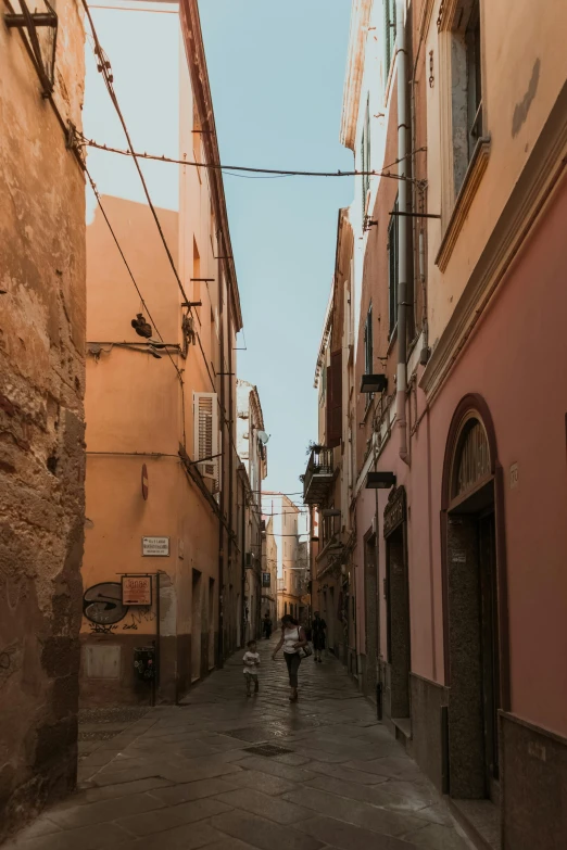 someone is walking down a narrow city street