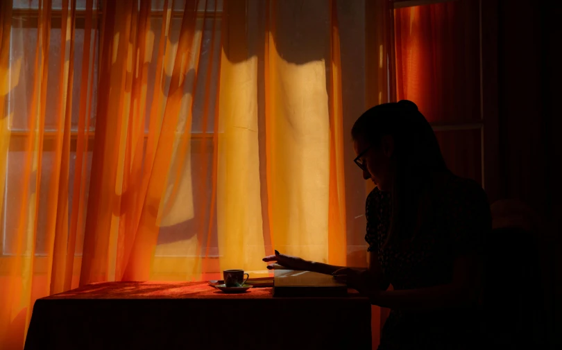 a woman is looking at her phone near a window