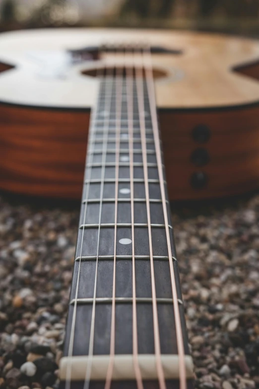 an acoustic guitar is placed on the ground