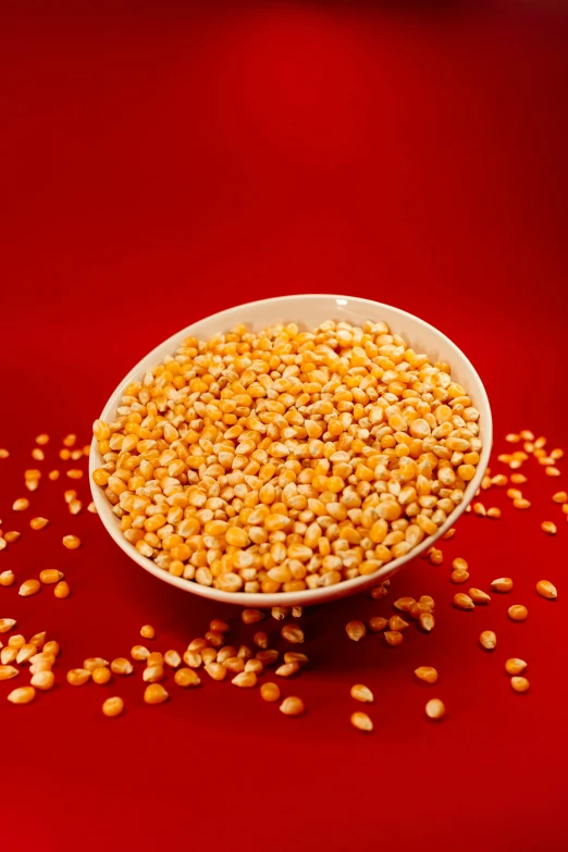 a bowl of cooked kernels, on top of a red table