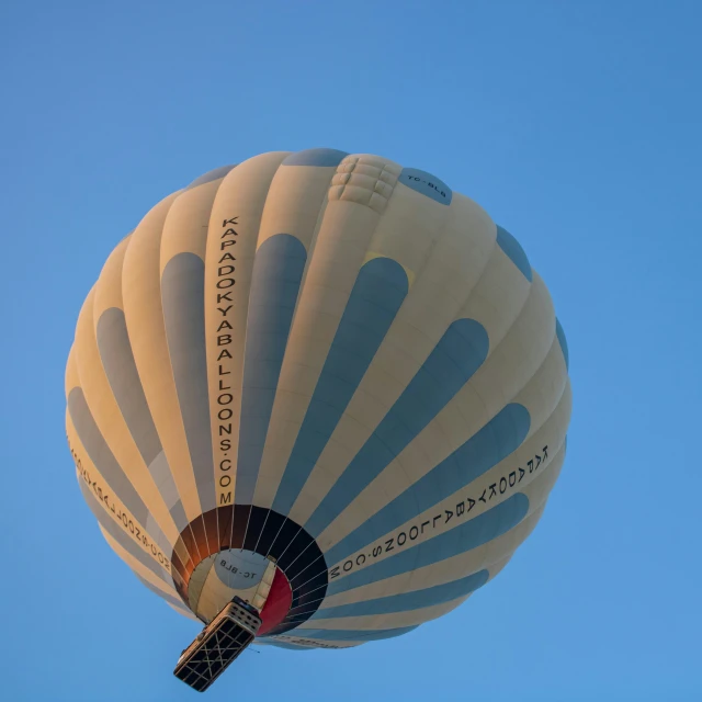 the blue and white  air balloon is flying in a clear blue sky