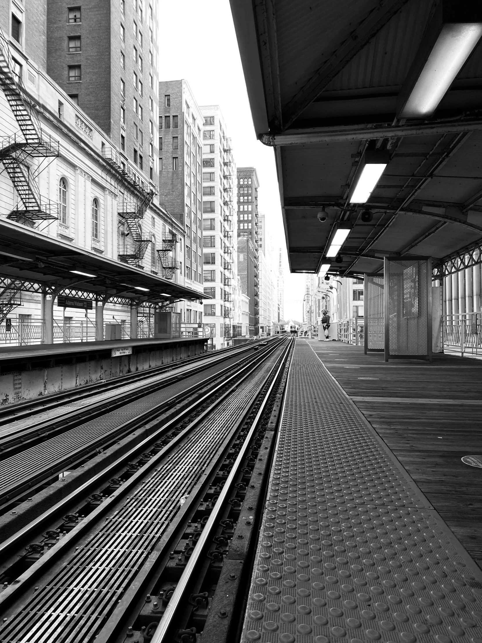 the empty city train platform is in the middle of black and white