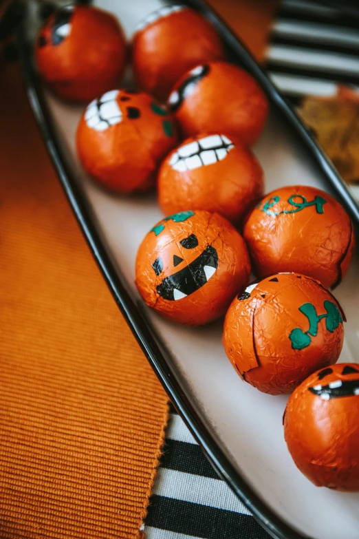 some oranges with green designs on them and painted face