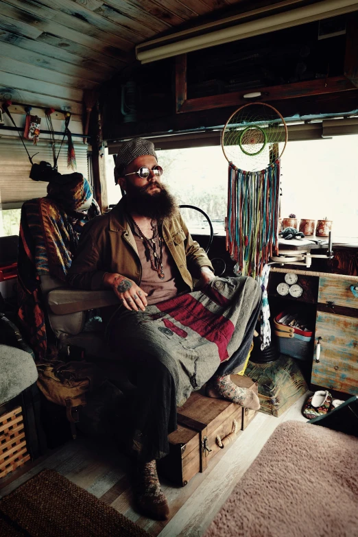 two people sit in a camper next to a shelf filled with clothes