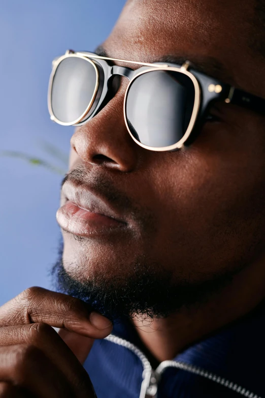 a man in sunglasses and shirt adjusting his bow tie