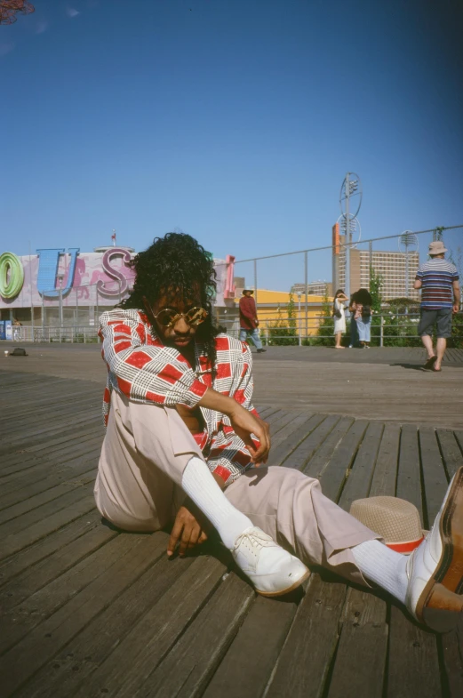 a person with long hair sitting on a wooden deck