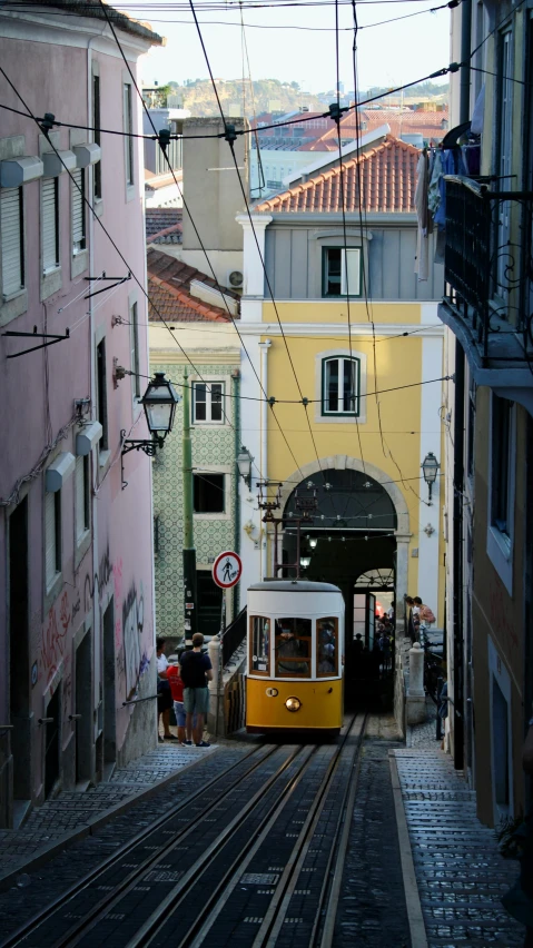 an old cable car with a yellow top and people boarding