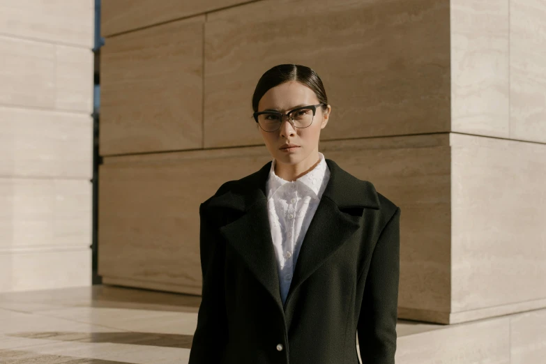 a woman standing outside in a black coat