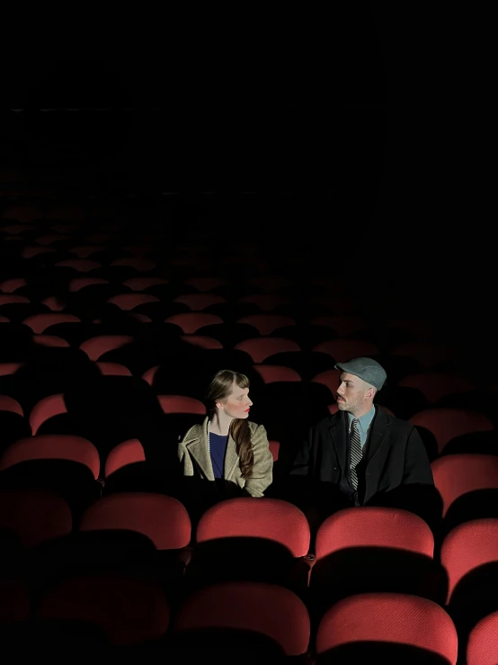 two people are sitting in the middle of an empty chair