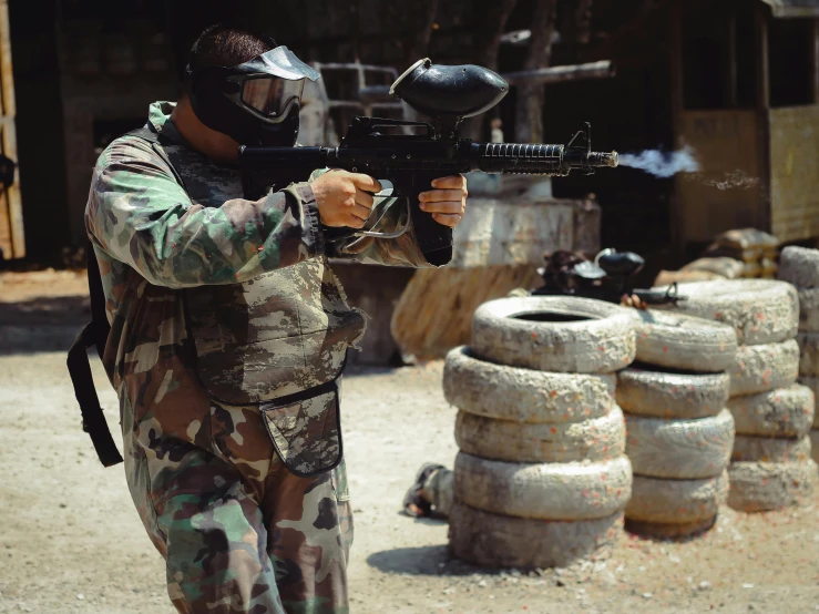 a soldier in camouflage aiming an arg rifle