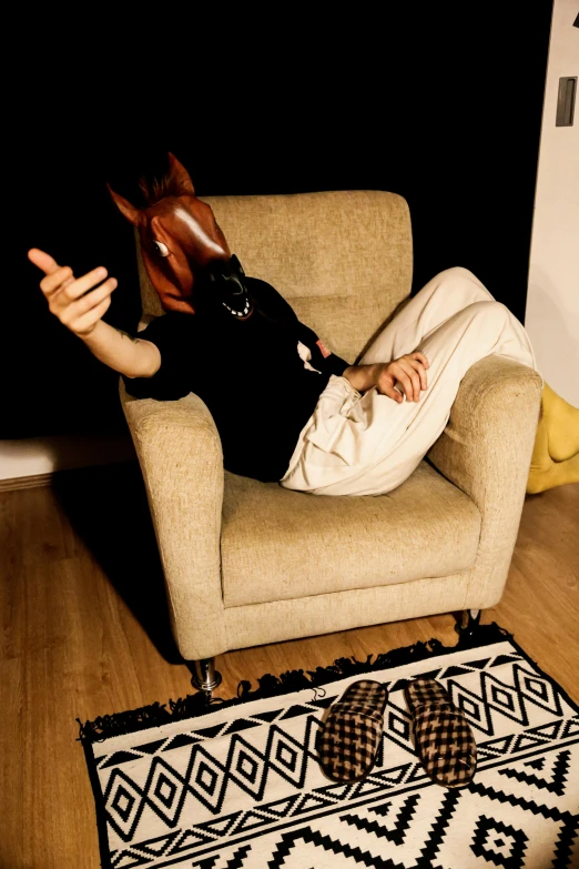 a woman sitting on a chair talking and holding her hand up