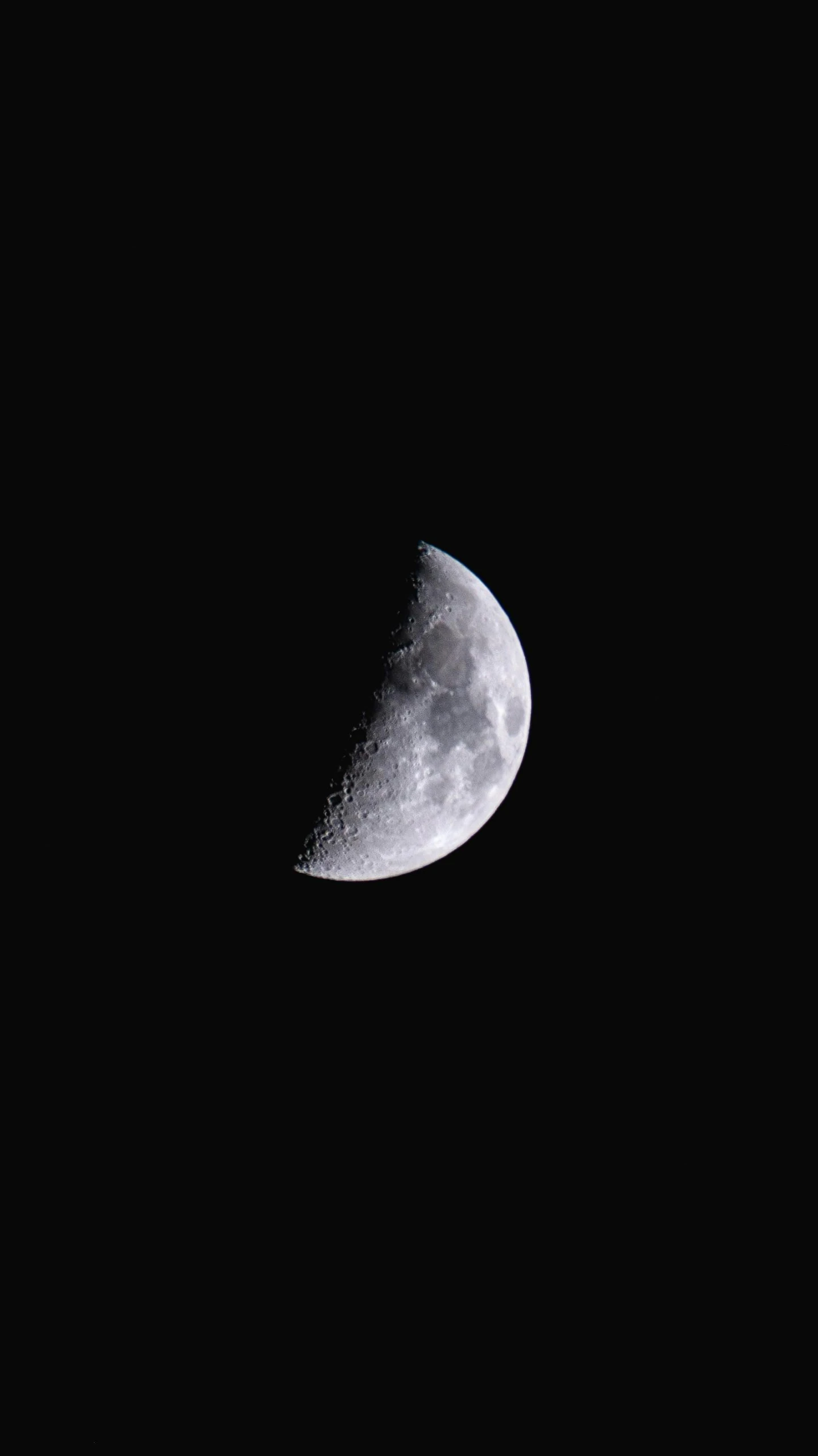 a large half moon lit up by the light of a street lamp