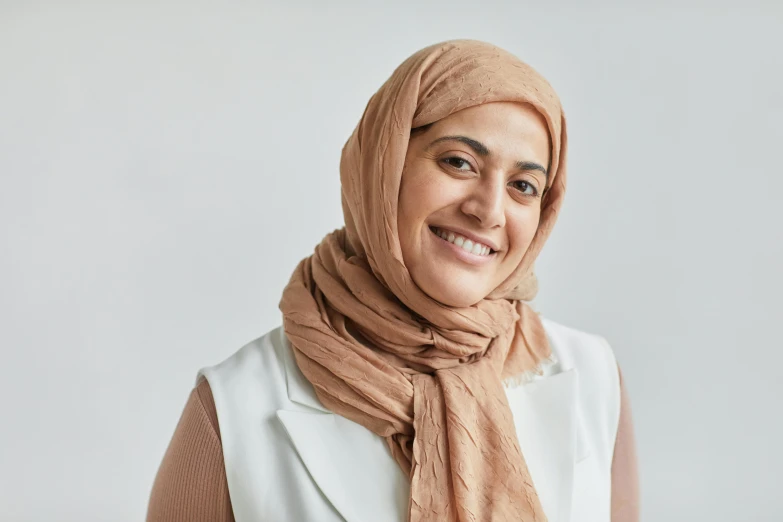 woman in head covering smiling and looking into camera