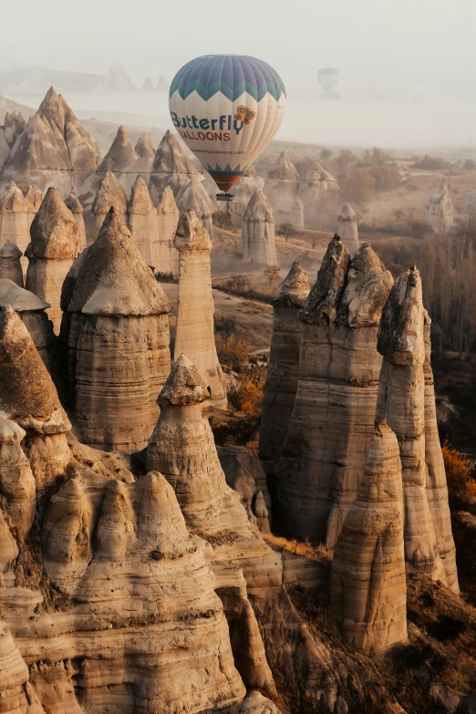  air balloons are in the sky near some large rocks