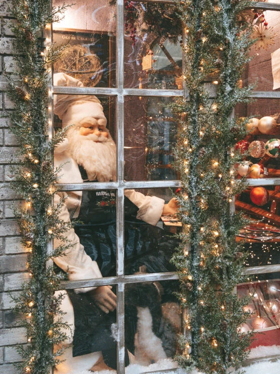 a santa clause sitting behind the window of a building