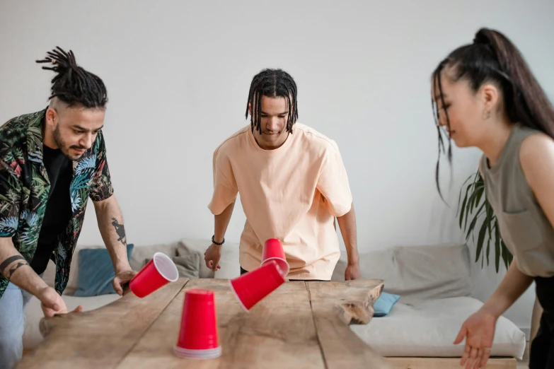 four young men and woman play a game with plastic cups