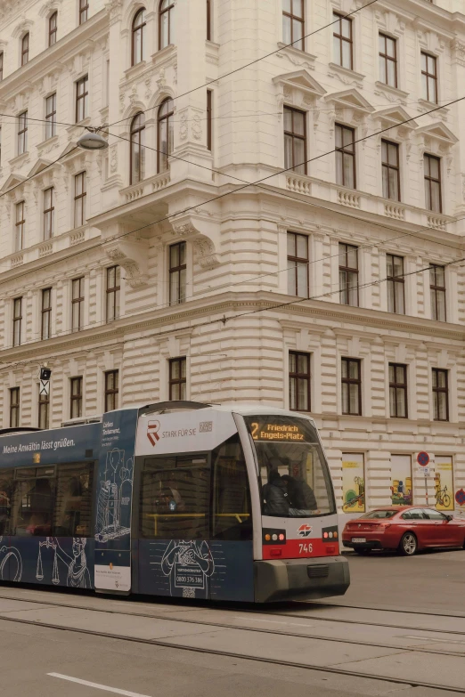 a blue bus sitting next to a tall white building