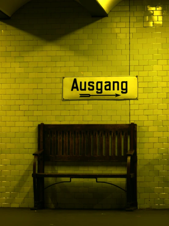 a bench next to a subway with the word ausgang